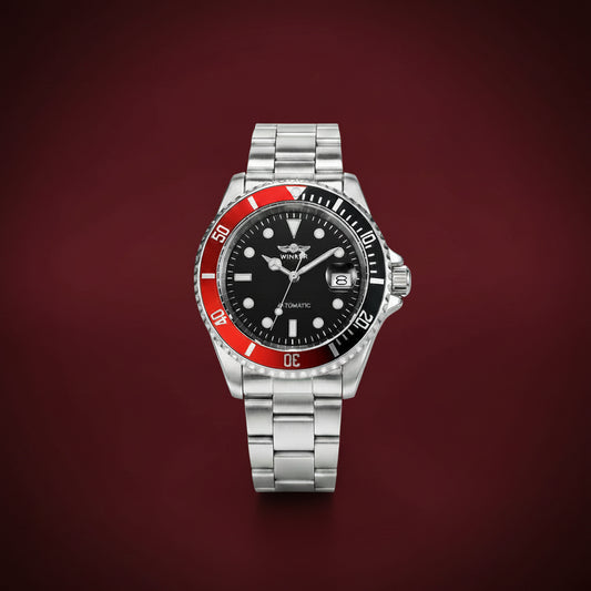 A stainless steel wristwatch with a black dial, silver-tone metal bracelet, and a red and black rotating bezel, centered on a dark red background by vigilia.